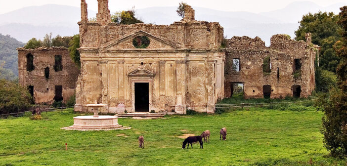 Foto della città fantasma di Monterano con cavalli bradi al pascolo